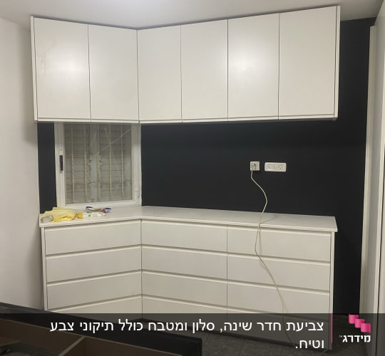 ארון לבן עם קיר צבוע בשחור מאחוריו